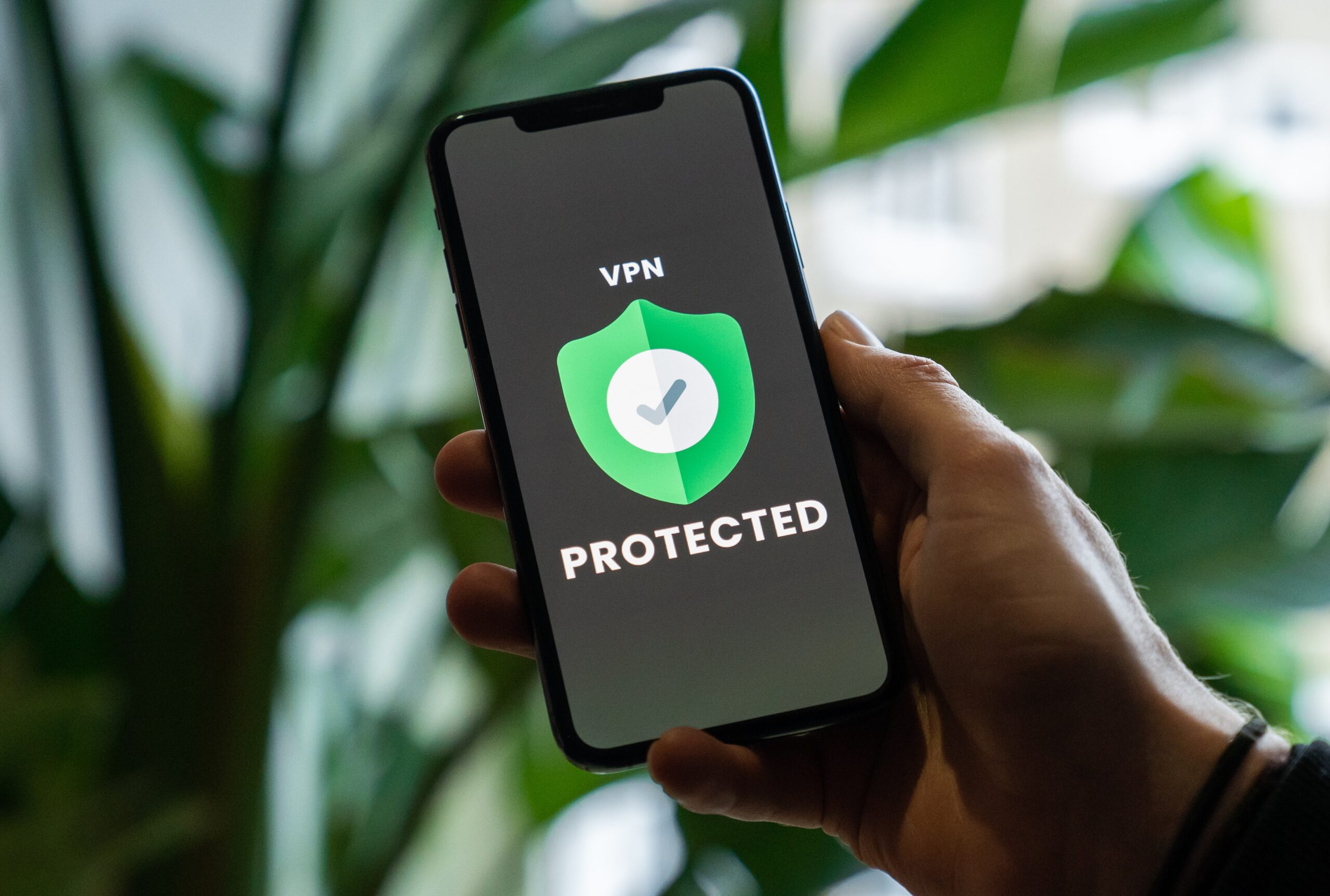 Person holding iPhone with VPN service enabled in hand
